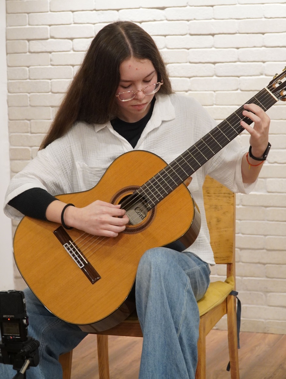 תלמיד מתקדם מבצע יצירה על גיטרה קלאסית